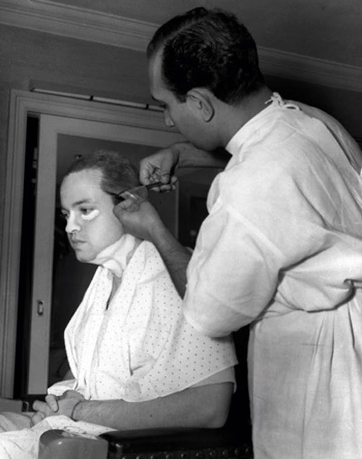 Photo of Orson Welles getting hair and makeup on “Citizen Kane”.