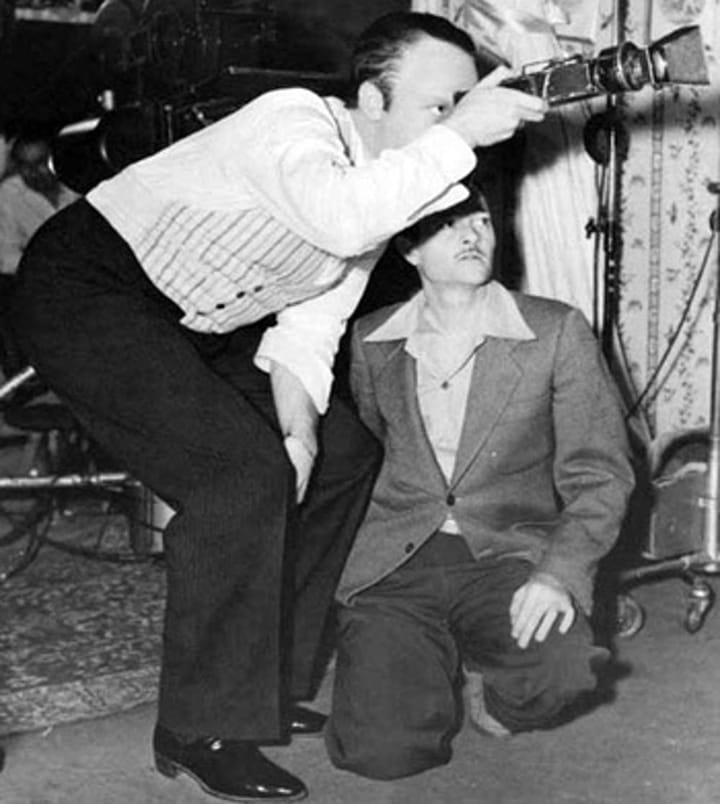 Photo of Orson Welles on the set of “Citizen Kane” checking the viewfinder with cinematographer Gregg Toland.